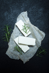 Wall Mural - Three pieces of organic feta cheese on the table, rosemary branches.