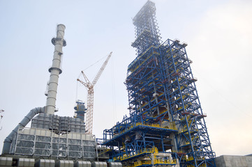 Wall Mural - Construction with cranes of a large blue chemical plant at an oil refinery, petrochemical plant.