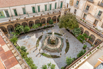 Wall Mural - The majolica cloister with fountain in courtyard of the Santa Caterina church, Palermo, Italy.