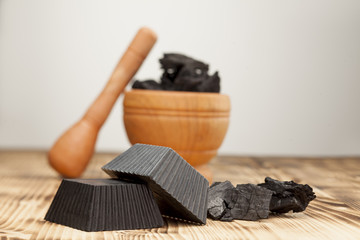 two hand made black soap from activated carbon on white background