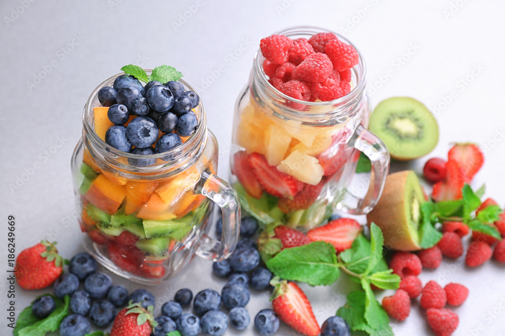 Mason jars with fruits and berries on table
