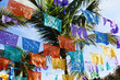 Colorful Mexican flag decorations hanging from palm trees