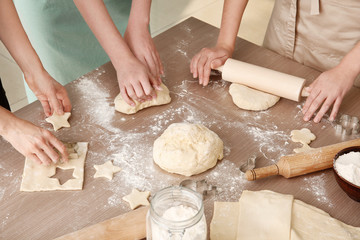 Canvas Print - Women preparing puff pastry at table in kitchen