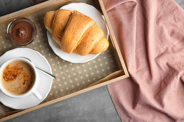 Wall Mural - Tray with yummy croissant and cup of coffee on table