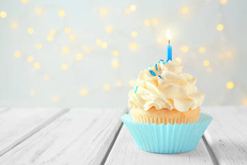 Poster - Tasty cupcake with candle on wooden table