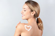 © Africa Studio - Young woman with heart made of body cream on her skin against light background