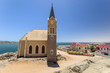 Beautiful panoramic view of the protestant german colonial church Felsenkirche in Lüderitz / Luderitz in Namibia, Africa. Parts of the town in the background.