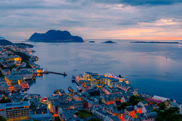 Wall Mural - Colorful sunset in Alesund port town on western coast of Norway. Place where the ocean meet the mountains