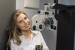 © FotoAndalucia - Woman ready for eye test with phoropter and calibrating glasses