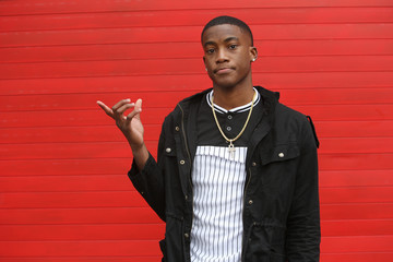 Portrait of a young African American male in expressive movement photo series on red background