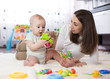 © Oksana Kuzmina - Funny baby and young woman playing in nursery. Happy family having fun with colorful toys at home.