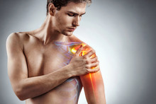 Man Holding His Injured Shoulder That's Highlighted In Red. Medical Concept.