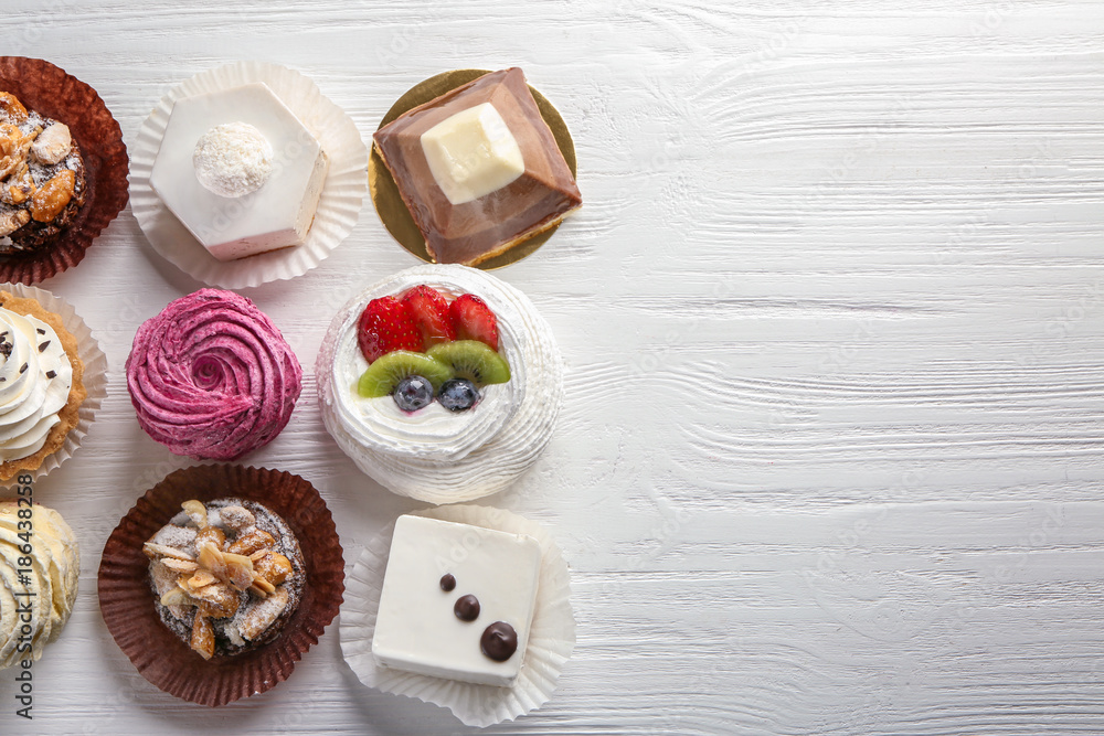Assortment of tasty sweets on wooden background