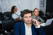 © okfoto - Young confident businessman talking by phone at office