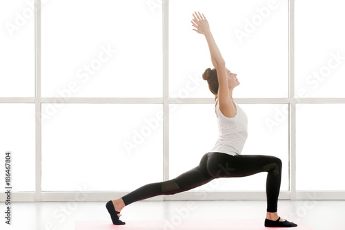Fotografía Woman looking up, hands up and doing yoga, warrior one posture