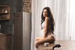 © LIGHTFIELD STUDIOS - sexy girl on lingerie sitting on table with cup of coffee and looking at camera
