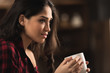 © LIGHTFIELD STUDIOS - side view of beautiful young woman holding cup of coffee and looking away