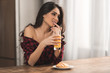 © LIGHTFIELD STUDIOS - sexy girl in checkered shirt eating croissant and drinking orange juice for breakfast