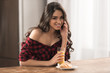 © LIGHTFIELD STUDIOS - beautiful girl in checkered shirt eating croissant and drinking orange juice for breakfast