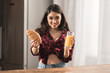 © LIGHTFIELD STUDIOS - attractive young woman in checkered shirt holding croissant and orange juice for breakfast