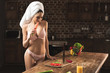 © LIGHTFIELD STUDIOS - sexy young woman in underwear and towel eating carrot while cooking at home