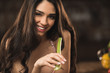 © LIGHTFIELD STUDIOS - seductive young woman eating celery and smiling at camera