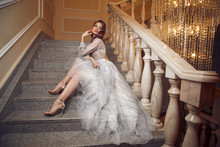 Full Lenght Portrait Of Gorgeous Woman In The Long Silver Dress On Stairs