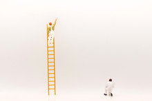 Miniature People, Mini Figure With Ladder And White Paint In Front Of A Wall And Another One Paint On Bottom Of Wall.