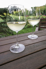 white wine glasses on wooden table at garden