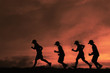silhouette boys running sunset