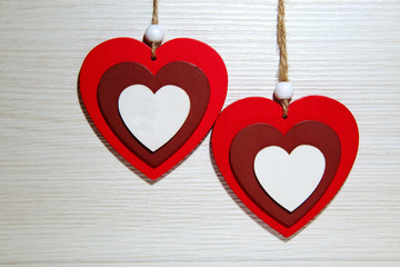 Two multicolored wooden hearts on a light background. Symbol of love and St. Valentine's Day.