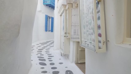 Wall Mural - 3 axis gimbal shot walking along a street of mykonos in greece past shops