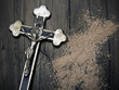 Krzyż i rozsypany popiół jako symbole Środy Popielcowej. Święto rozpoczynające Wielki Post.