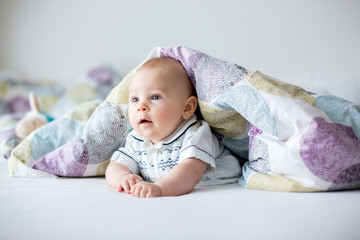 Wall Mural - Cute little four month old baby boy, playing at home in bed