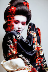 Wall Mural - young pretty geisha in kimono with sakura and red decoration design on white background