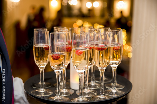 Fotografie, Obraz Waiter served champagne glasses on a tray in a fine dining restaurant