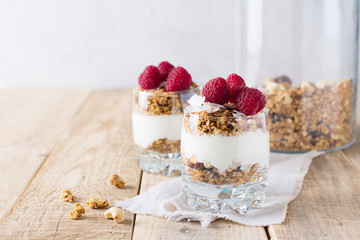 Wall Mural - Healthy breakfast with oats granola,raspberry and nuts over wooden table
