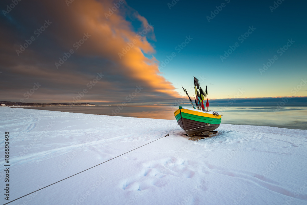 Fishing boat at snow covered beach in Sopot. Winter landscape. Poland. - obrazy, fototapety, plakaty 