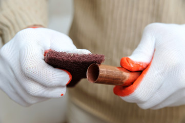 Wall Mural - A worker is rubbing the copper tube.