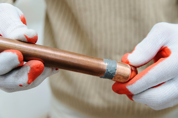 Wall Mural - A worker is connecting copper pipes.