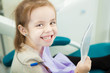 © Ilshat - Little child looks at snowy white teeth in mirror