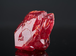 Red natural crystal mineral on a black background