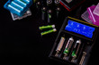 Electronic Chargers with display for rechargeable batteries with many batteries on black background.