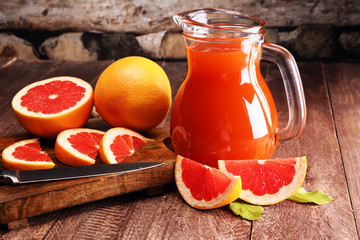 Wall Mural - Grapefruit juice and ripe grapefruits on a wooden background