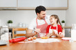 © jpleskachevskaia - Affectionate brunet young male embraces daughter, sit together at kitchen, bake something delicious, prepare surprise for mother, surrounded with ingredients, mix eggs in bowl. Parenthood concept.