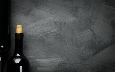 Glass bottle of wine with corks on wooden table background