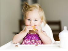 Portrait Of Cute Baby Girl Eating Food