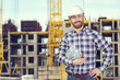 © fotofabrika - Young male engineer with helmet holding blueprints