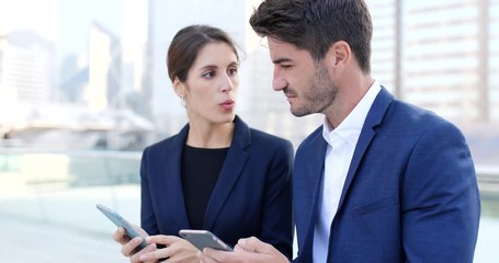 Wall Mural - Business man and businesswoman using smart phone together for sharing information outside office