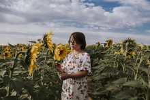 Girl Standing In Sunflower Field Against Sky